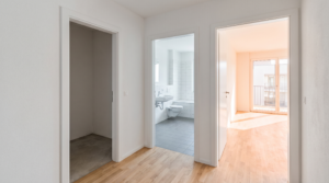 Was zählt zur Wohnfläche – Blick durch eine leere Wohnung auf Wohnraum, Abstellraum und Bad